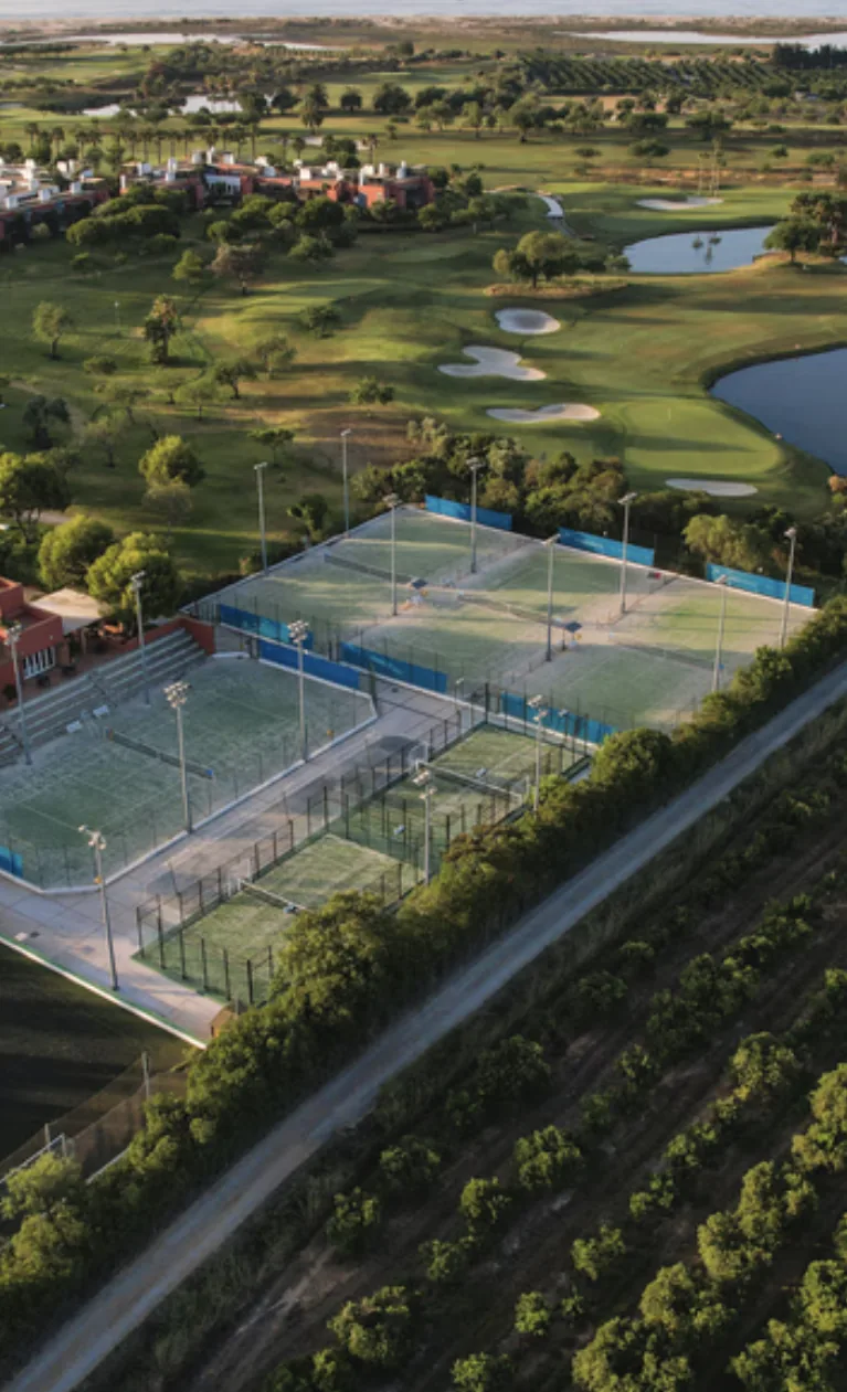 Aerial view of a multi-court padel destination beside a championship golf course